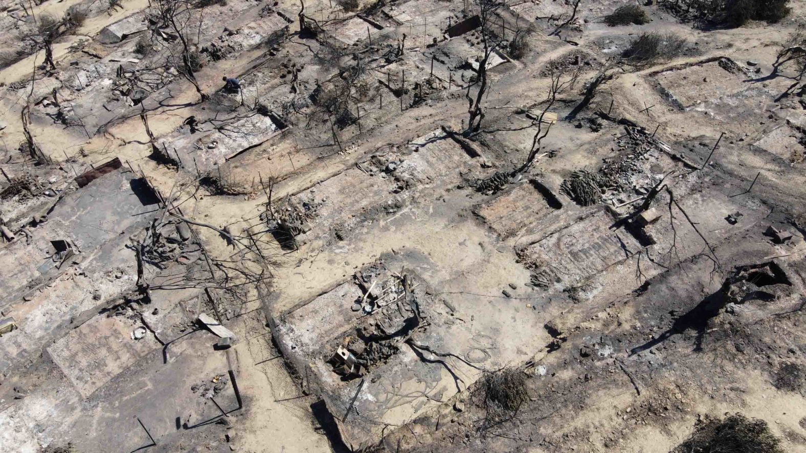 An aerial view shows destroyed shelters.
