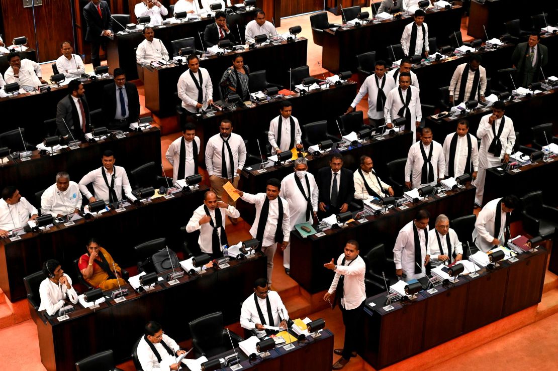 Sri Lankan opposition legislators, wearing black shawls, protest in parliament as convicted murderer Premalal Jayasekara is sworn in.