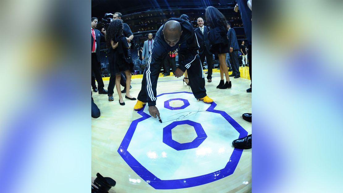 Kobe Bryant signs the floor at his final game.