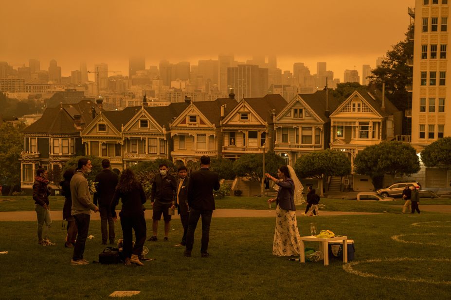 People stand in Alamo Square Park as smoke hangs over San Francisco on September 9, 2020.