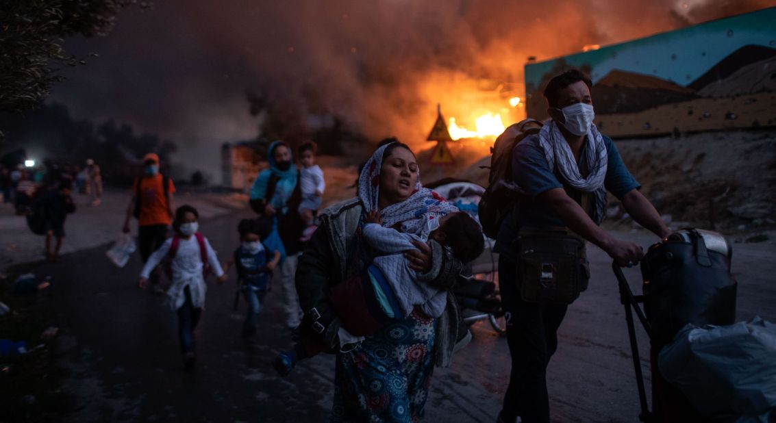 Migrants flee the camp as a second fire breaks out on Wednesday, September 9.