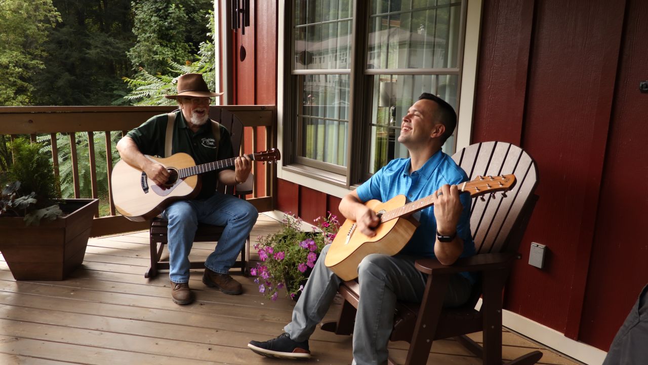 Master luthier Doug Naselroad (left) plays a tune with his mentee Earl Moore, who's holding one of 70 guitars he's made as an artist-in-residence at the Appalachian Artisan Center. 
