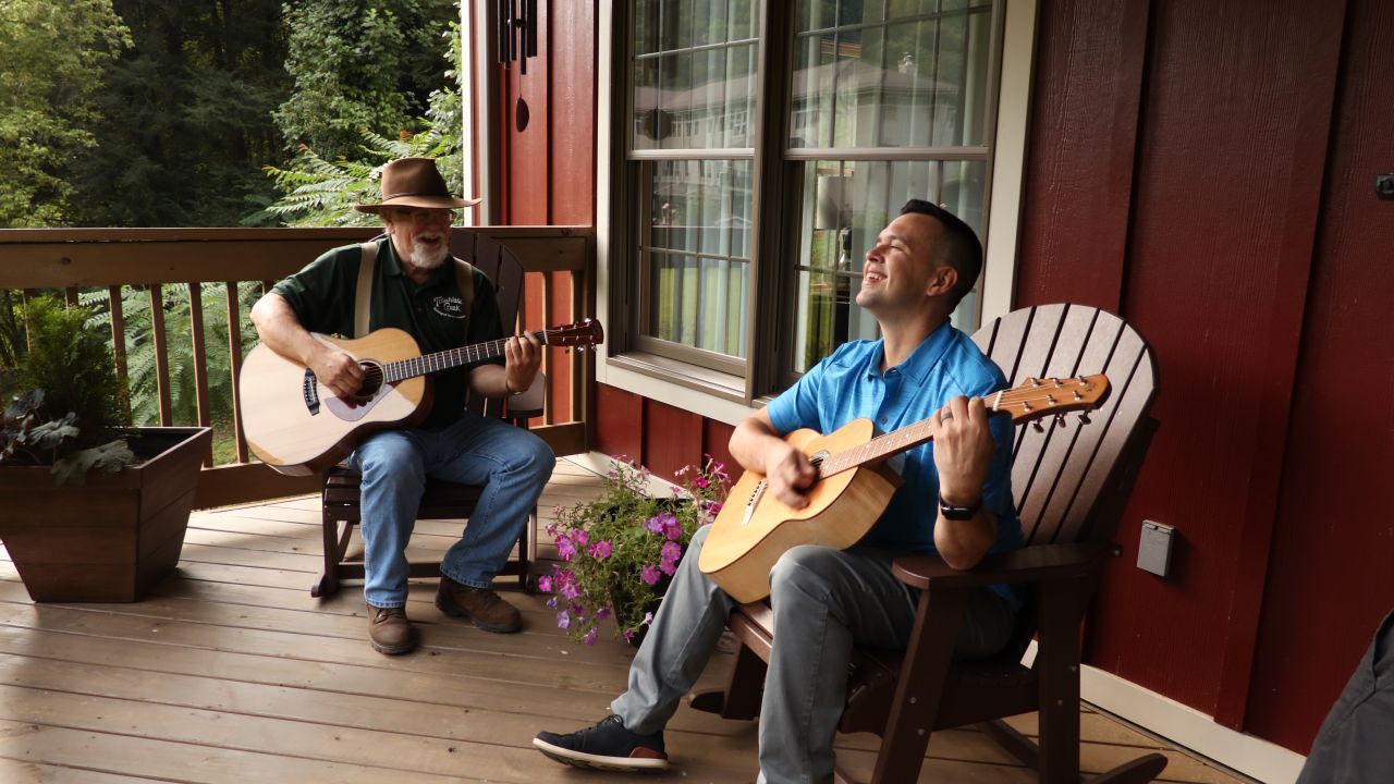 Master luthier Doug Naselroad (left) plays a tune with his mentee Earl Moore, who's holding one of 70 guitars he's made as an artist-in-residence at the Appalachian Artisan Center.