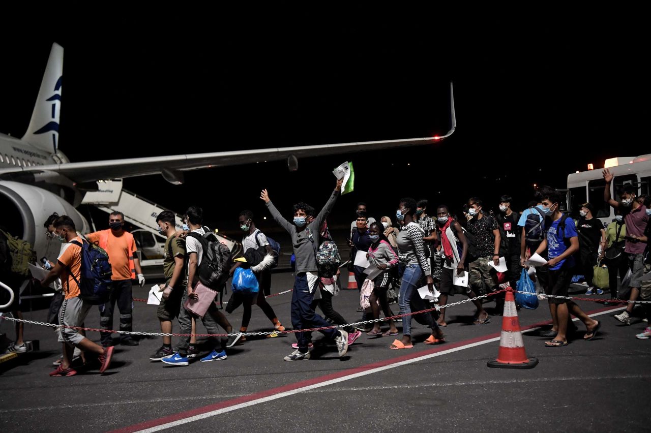 Unaccompanied minors from the migrant camp board a plane to be transferred to camps in northern Greece.