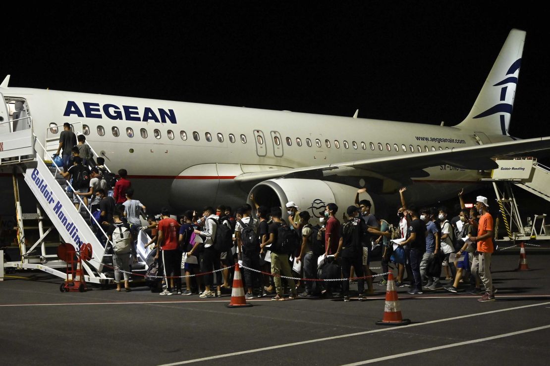 A group of children board one of three planes taking 406 unaccompanied minors from the burned camp to mainland Greece on Wednesday night.