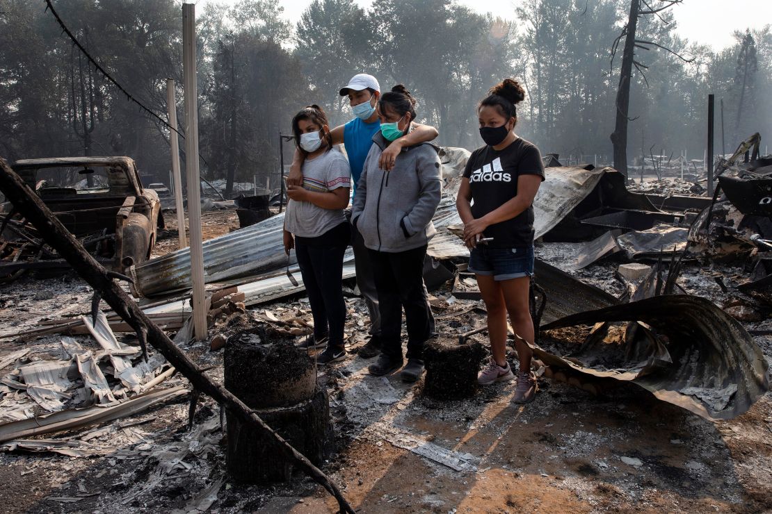 A family looks at the destruction of their home at Coleman Creek Estates mobile home park in Phoenix, Oregon, on Thursday. 