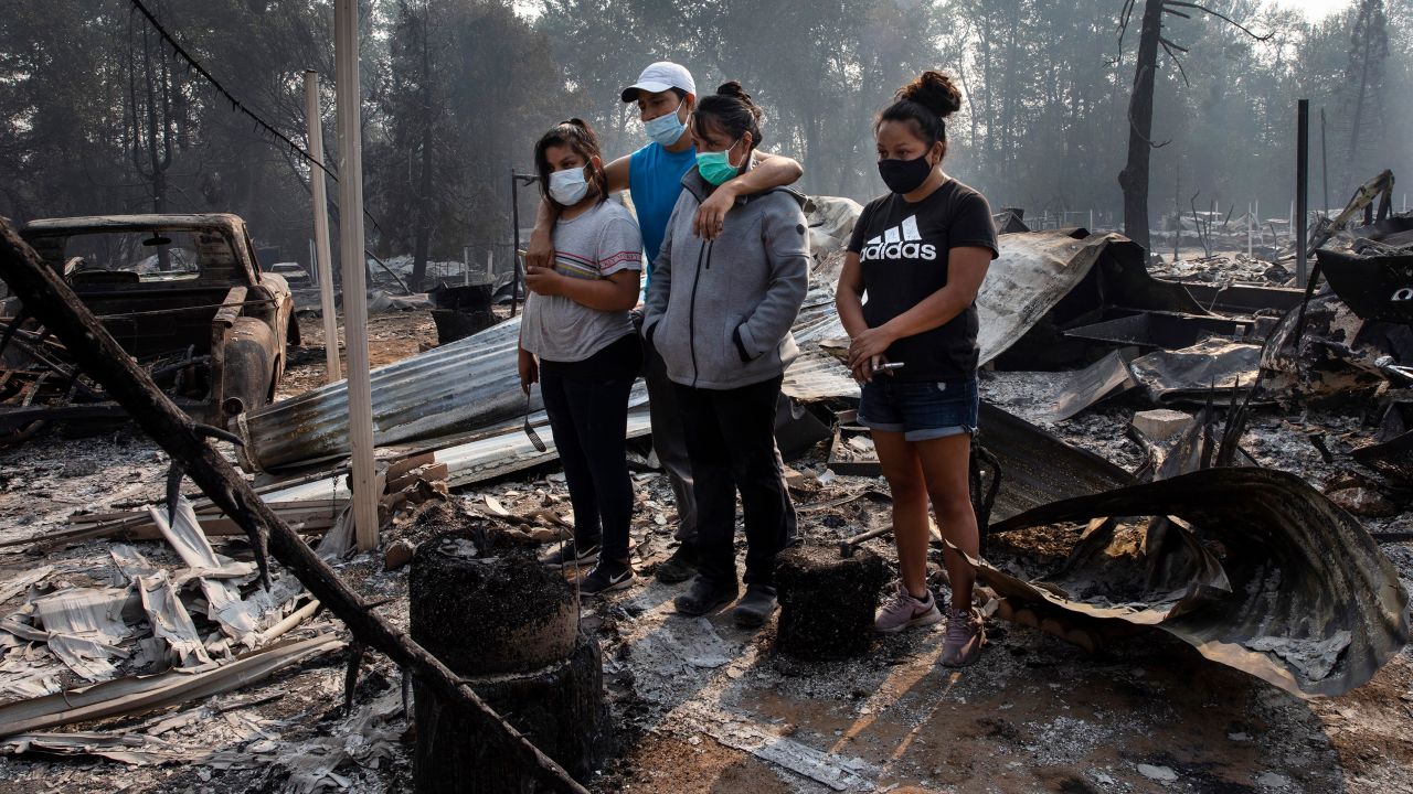 A family looks at the destruction of their home at Coleman Creek Estates mobile home park in Phoenix, Oregon, on Thursday. 