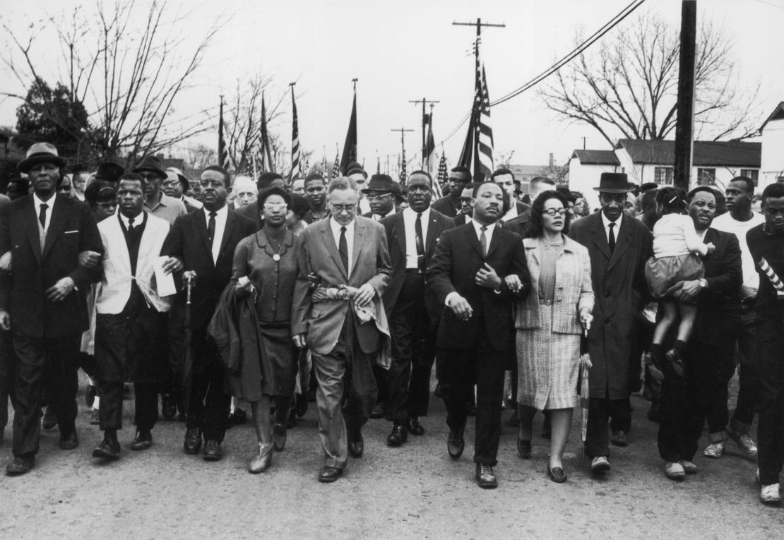 March 1965:  American civil rights campaigner Martin Luther King (1929  - 1968) and his wife Coretta Scott King lead a black voting rights march from Selma, Alabama, to the state capital in Montgomery;  among those pictured are, front row, politician and civil rights activist John Lewis (1940 -- 2020), Reverend Ralph Abernathy (1926 - 1990), Ruth Harris Bunche (1906 - 1988), Nobel Prize-winning political scientist and diplomat Ralph Bunche (1904 - 1971), activist Hosea Williams  (1926 -- 2000). (Photo by William Lovelace/Express/Getty Images)