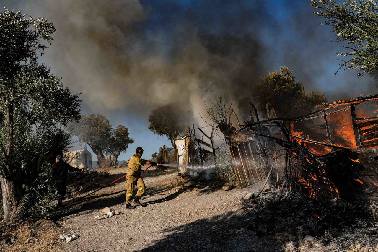 A firefighter works to put out a flame as fires continue to burn in the camp on September 10.