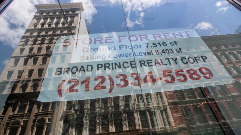 A "for rent" sign hangs in the window of an empty storefront in New York City.