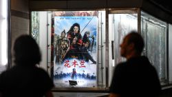 People walk past a poster of the Disney movie 'Mulan' outside a cinema in Beijing on September 10, 2020. Disney's "Mulan" remake is facing fresh boycott calls after it emerged some of the blockbuster's scenes were filmed in China's Xinjiang, where widespread rights abuses against the region's Muslim population have been widely documented. The movie will open in Beijing on September 11.