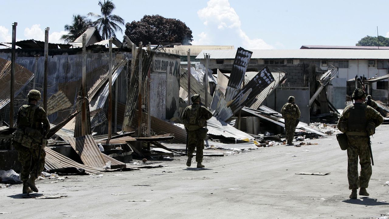 Australian soldiers patrol through Honiara's Chinatown in the Solomon Islands on April 22, 2006. All of Chinatown has been locked down as a crime scene.