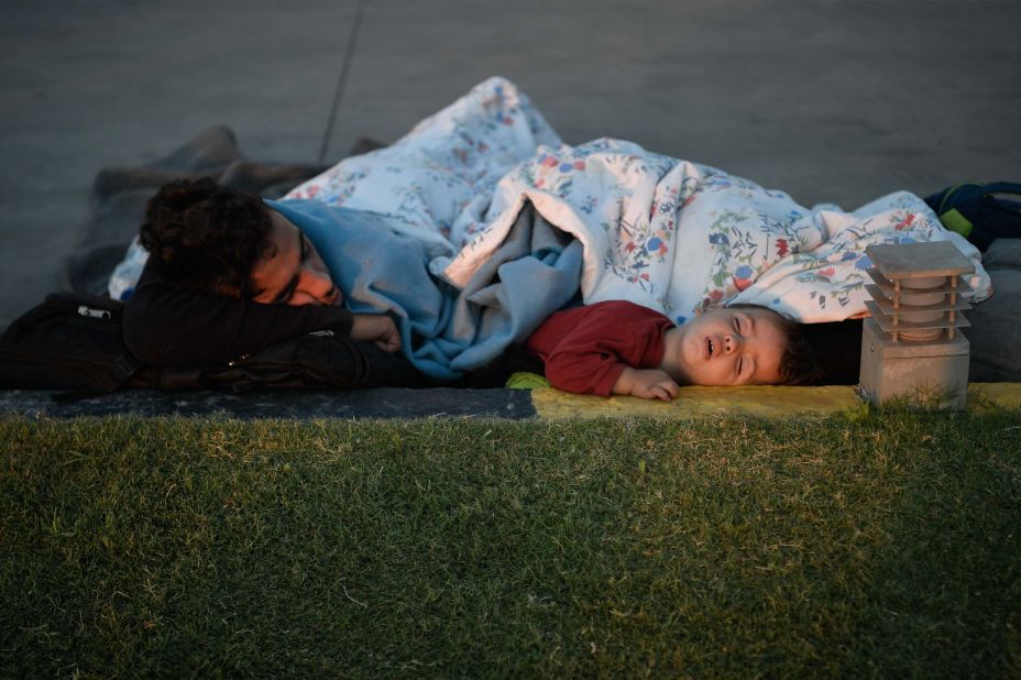 A displaced family sleeps at a gas station early on September 11.