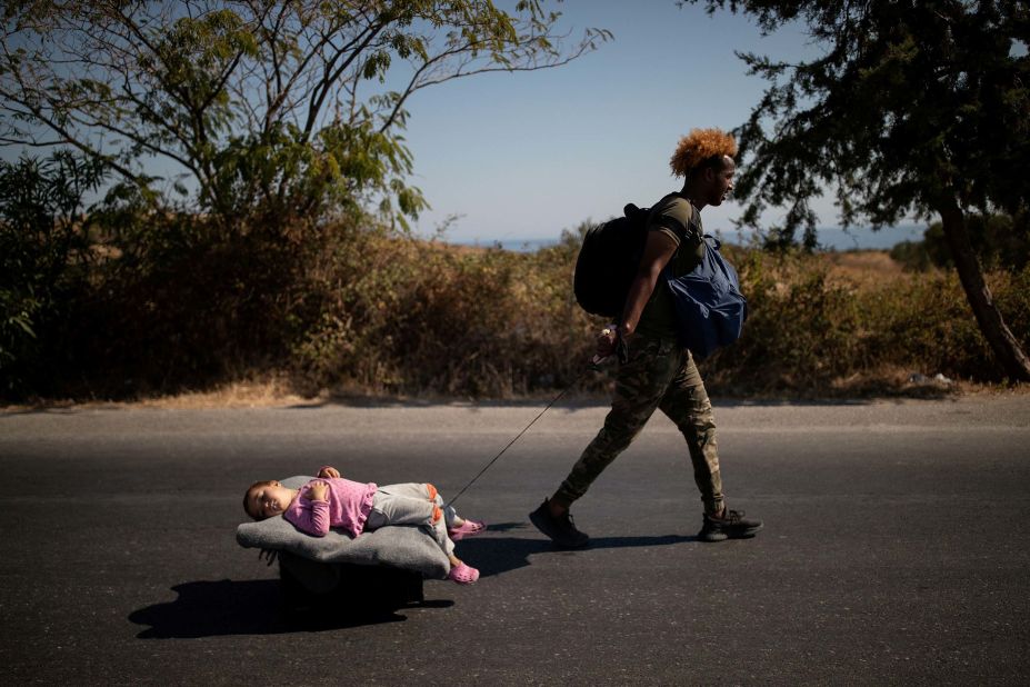 A migrant pulls a young girl on a cart on September 11.