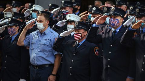 Firefighters salute in front of Ladder 10 Engine 10 near the 9/11 memorial on Friday.