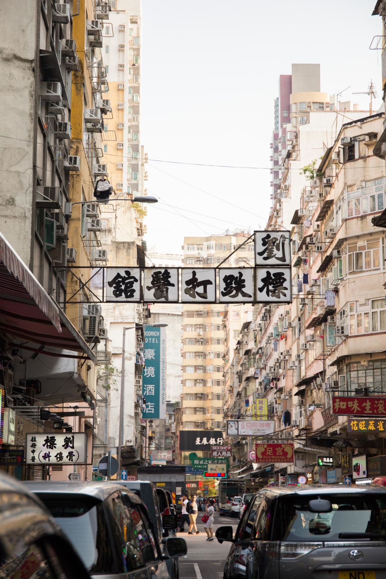 A black and white sign -- written in the Beiwei Kaishu style -- draws attention to a chiropractor's clinic in Hong Kong's Yau Ma Tei district.