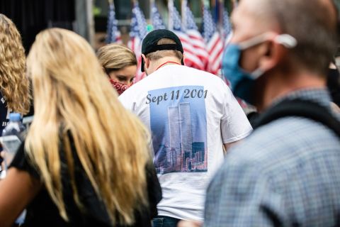 The World Trade Center towers are seen on a man's T-shirt in the crowd.