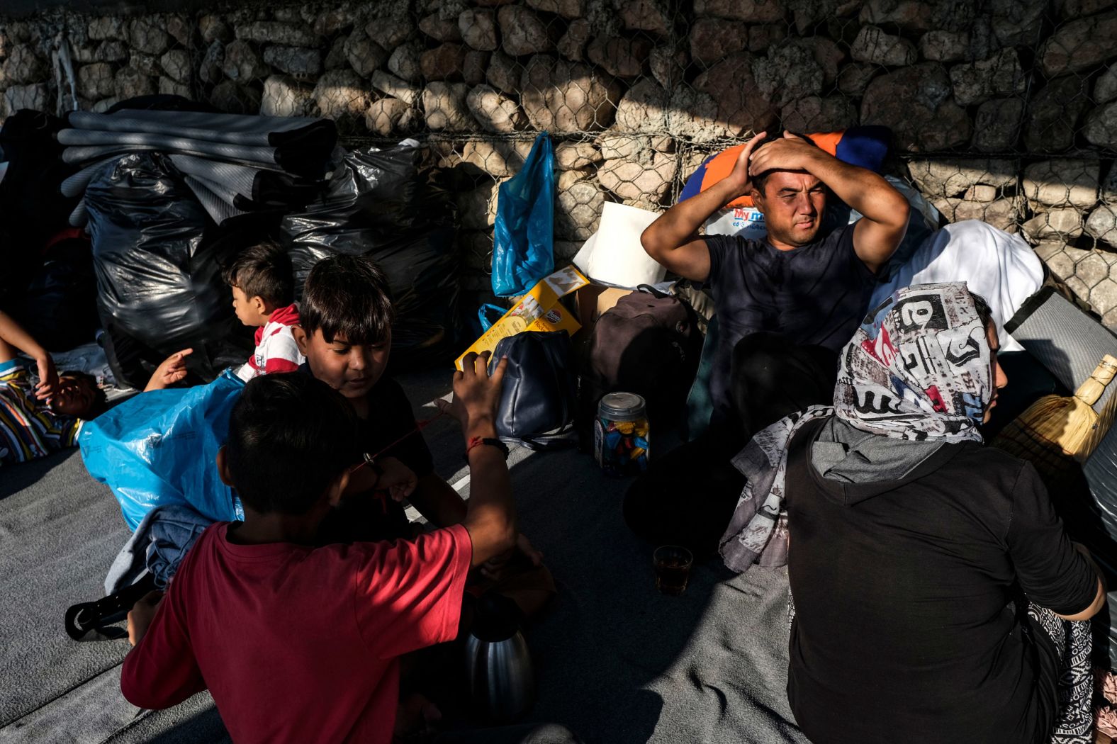 An Afghan family wakes up Friday, September 11, in the aftermath of the Moria fires.