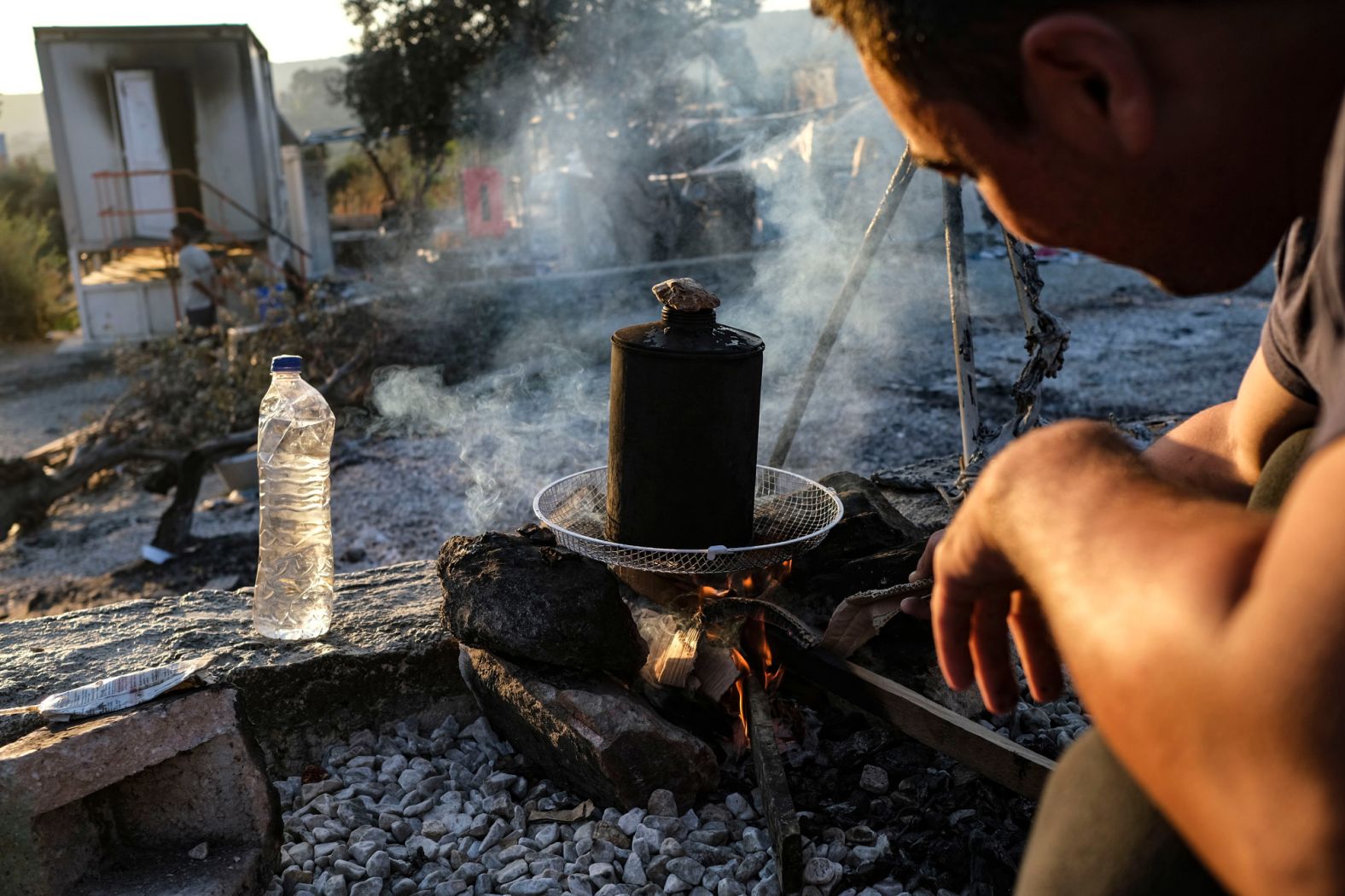 An Afghan migrant starts a fire for his family's morning tea on September 11.