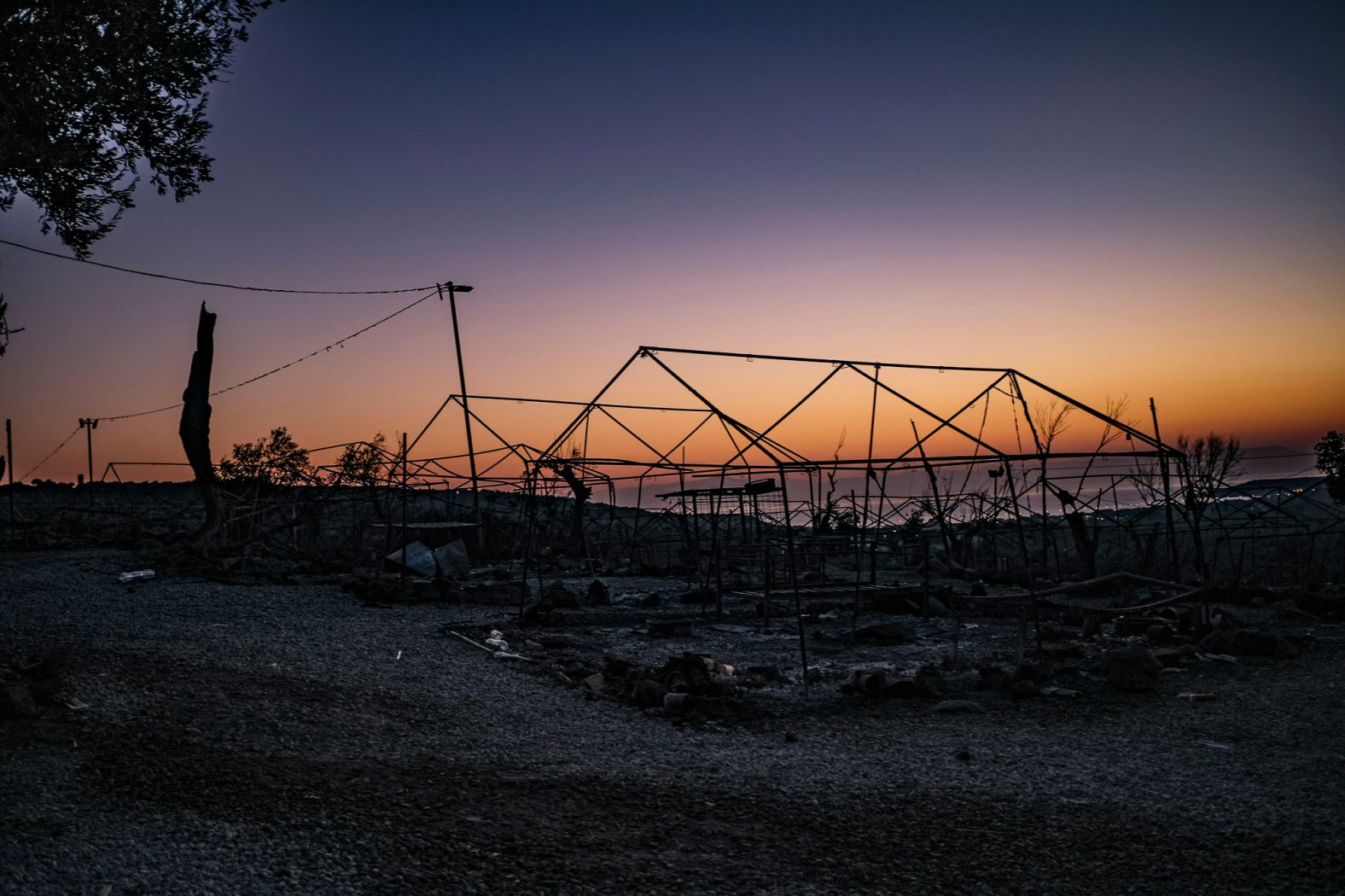 The sun rises over the burned-out camp on September 11.