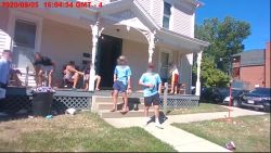 Body camera video from the Oxford Police Department shows a group of men gathered on the porch of a home near the university's campus on September 5.  CNN has blurred the faces of those pictured to protect their identity.