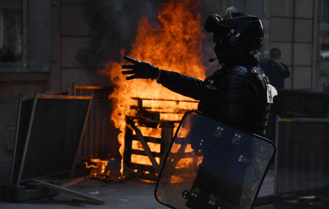 A riot police officer stands near a fire during a yellow vest protest in Paris on September 12.