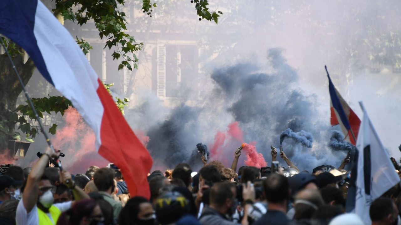 Flares are lit by demonstrators during a yellow vest protest in Paris on September 12, 2020. 