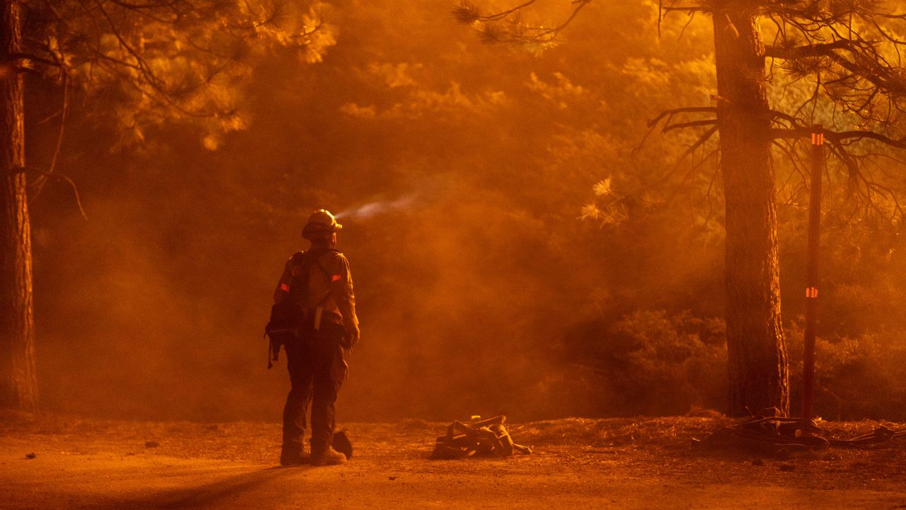 A firefighter watches flames near the Angeles Crest Highway at the Bobcat Fire north of Monrovia, California, on Friday.