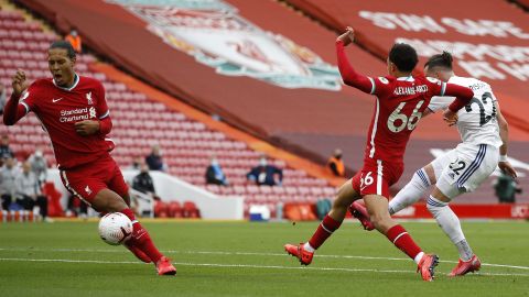 Jack Harrison of Leeds United scores his team's opening goal at Anfield as he shoots home past Liverpool defenders Trent Alexander-Arnold and Virgil Van Dijk.