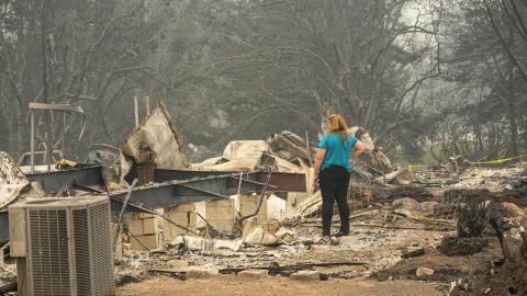 A woman surveys the damage to a home owned by her son in a mobile home park on September 11, 2020 in Ashland, Oregon.