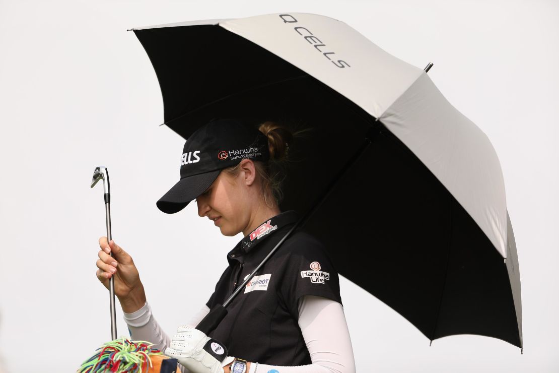 Nelly Korda of the United States takes shelter from the sun as she selects a club from her bag during her third round at Mission Hills.