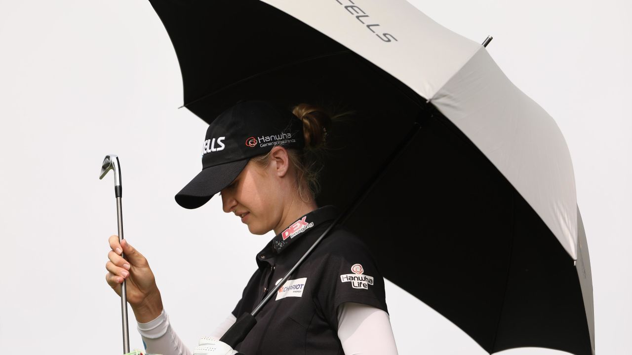 Nelly Korda of the United States takes shelter from the sun as she selects a club from her bag during her third round at Mission Hills.