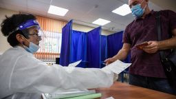A ballot is handed to a voter in Novosibirsk, Russia on September 13, 2020, as Russians vote in regional polls. 