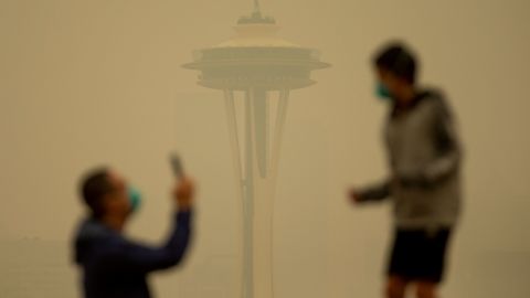 Smoke obscures the Space Needle as people take photos in Seattle's Kerry Park on Saturday. 