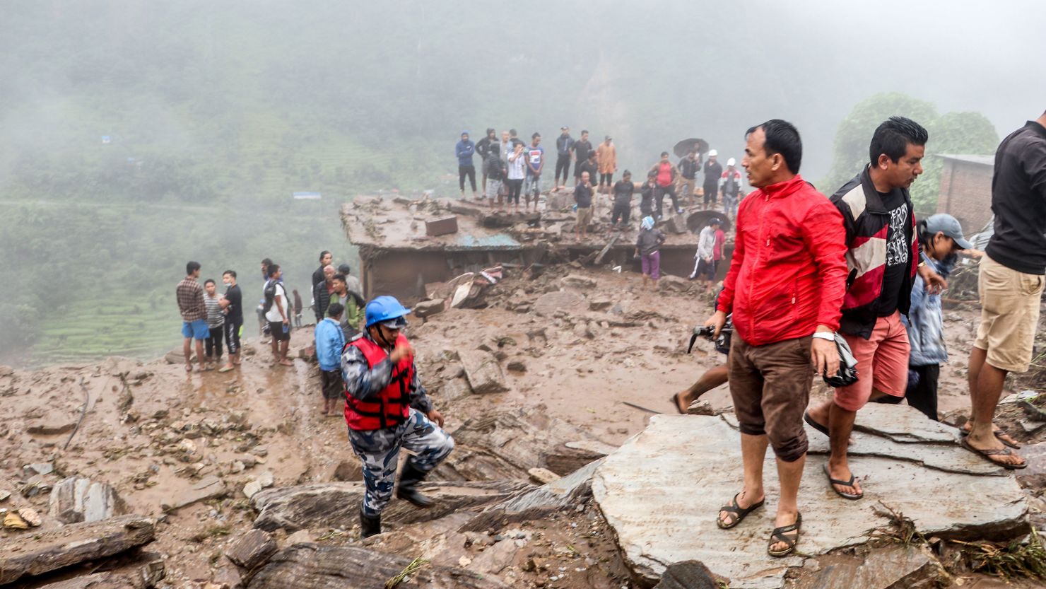 Rescue workers and residents gather for search at the scene of a landslide following heavy rains in Bahrabise municipality of Sindhupalchok district.