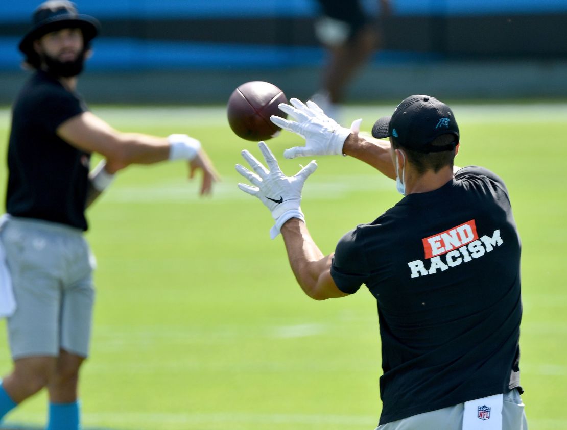Carolina Panthers players wear End Racism shirts as they warm up before a game against the Las Vegas Raiders on September 13, 2020 in Charlotte, North Carolina.