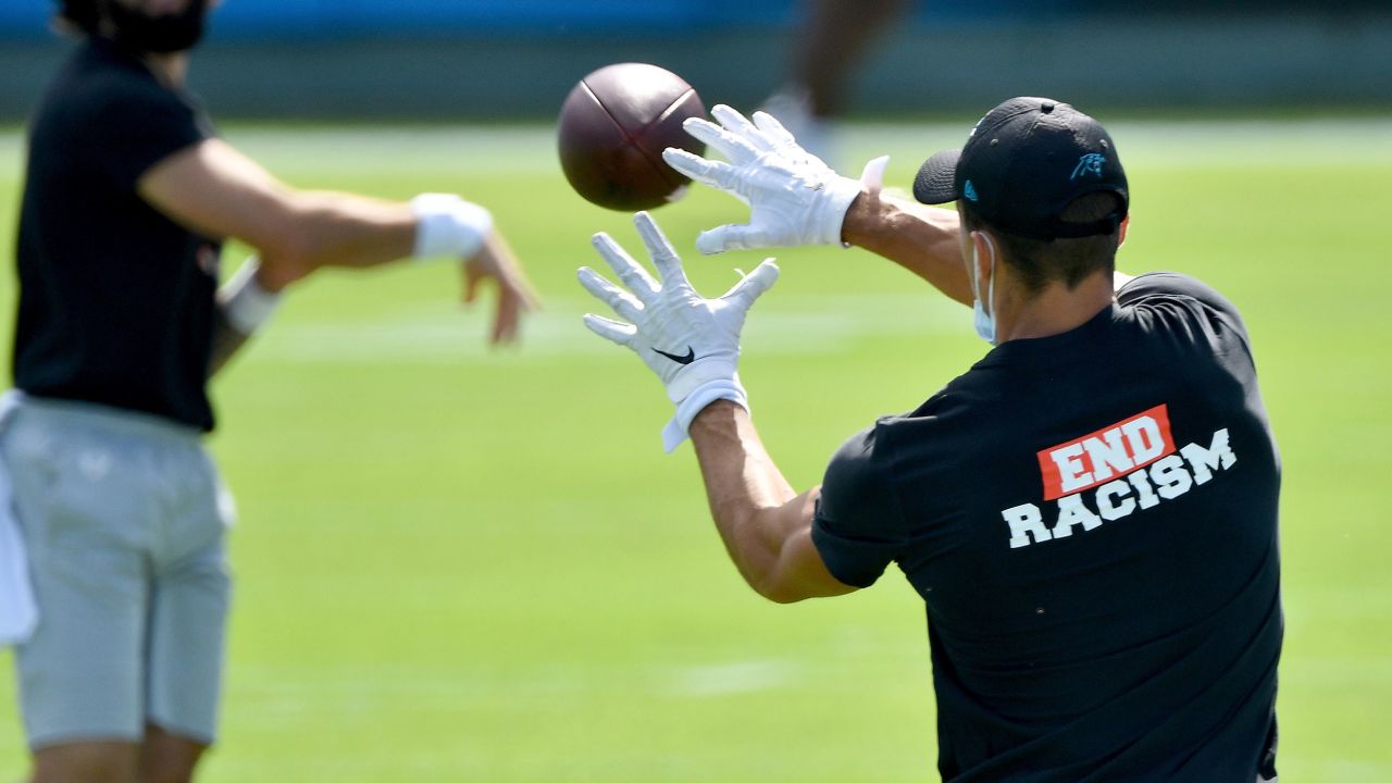 Carolina Panthers players wear End Racism shirts as they warm up before a game against the Las Vegas Raiders on September 13, 2020 in Charlotte, North Carolina.