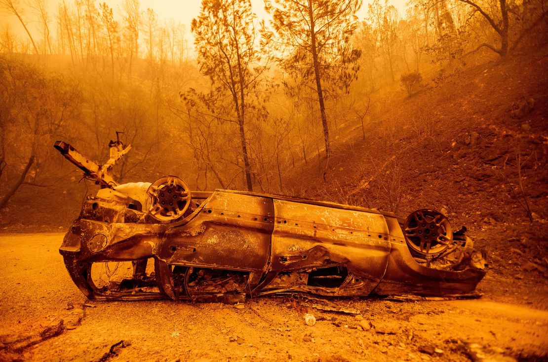 The charred remains of a vehicle are left on the side of a road during the Bear Fire, part of the North Lightning Complex.