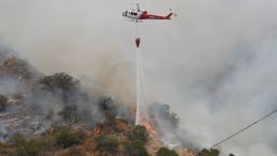 A helicopter drops water to help extinguish the Bobcat Fire, in Arcadia, California, U.S., September 13, 2020. Mario Anzuoni/Reuters