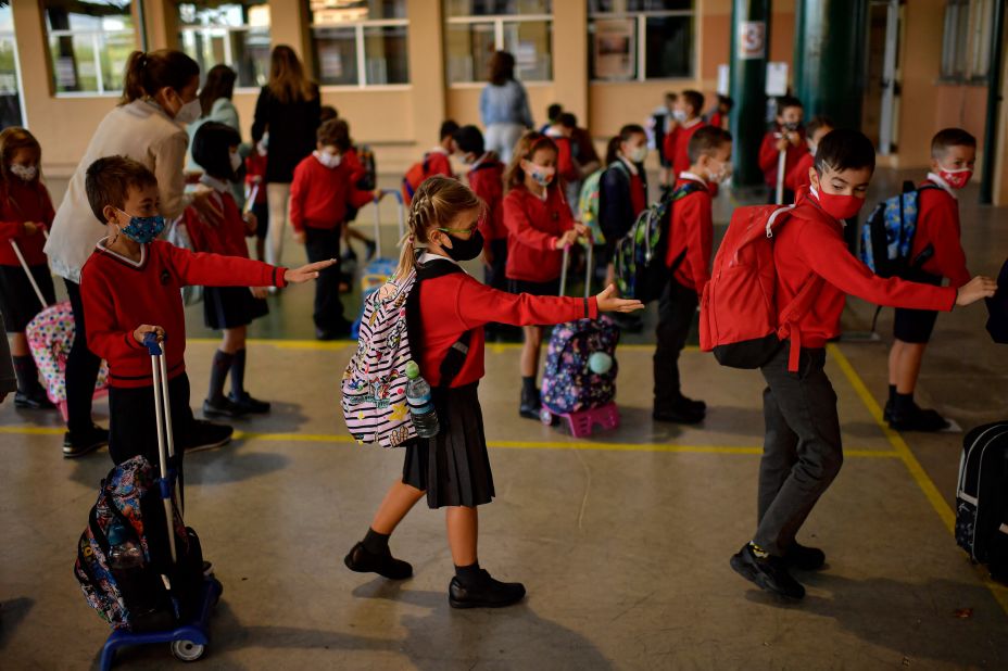Young students make sure they are spread out from one another as they stand in a line before entering a classroom in Pamplona, Spain, on September 7.