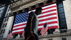 People walk by the New York Stock Exchange (NYSE) near One World Trade Center, the Freedom Tower, in lower Manhattan during commemoration ceremonies for the September 11, 2001 terror attacks on September 11, 2020 in New York City. Hundreds of people have gathered for the 19th anniversary of the event at Ground Zero to remember the nearly 3,000 who were killed on that day. But this year, due to COVID-19 pandemic restrictions, only family members are allowed to gather at the 9/11 Memorial plaza. There will also not be an in-person reading of the victims' names at the memorial and instead there will be a pre-recording of names by family members broadcast throughout the plaza and live-streamed online.  (Photo by Spencer Platt/Getty Images)