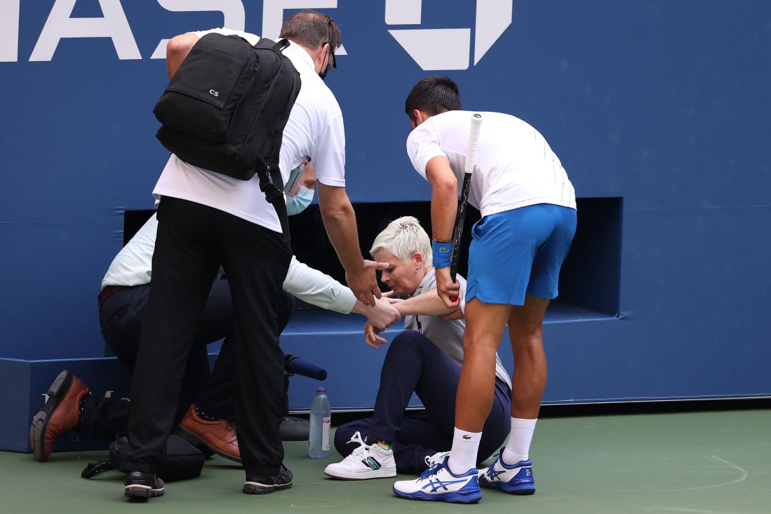 Djokovic tends to the judge after striking her with a ball. 