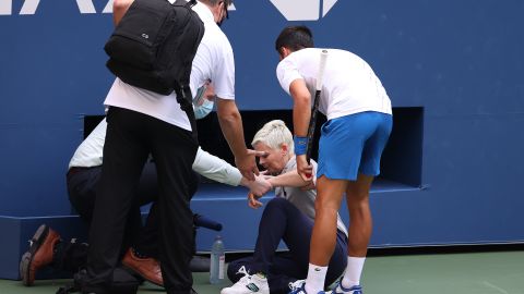Djokovic tends to the judge after striking her with a ball. 