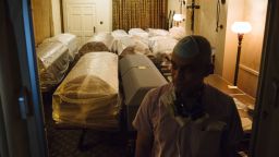 A funeral director stands in front of empty caskets for victims of Covid-19 stored in a room at a funeral home in the Queens borough of New York, U.S., on Wednesday, April 29, 2020. While New York saw 306 virus deaths Wednesday, the fifth day of decline, the state has reported more than 18,000 deaths from the virus. Photographer: Angus Mordant/Bloomberg via Getty Images