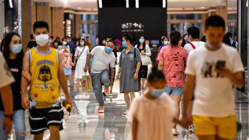 In this photo taken on September 5, 2020, people wearing face masks walk in a shopping mall in Wuhan, China's central Hubei province. - China is recasting Wuhan as a heroic coronavirus victim and trying to throw doubt on the pandemic&apos