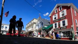 Tourists walk by newly reopened shops, Tuesday, June 9, 2020, in Boothbay Harbor, Maine. Many Maine tourists towns have seen a sharp drop in the number of visitors due to the coronavirus pandemic. (AP Photo/Robert F. Bukaty)