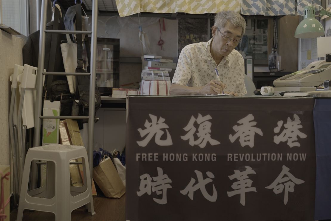 Lam Wing-kee in his Taipei book shop, where a banner displays slogans which have been declared subversive in Hong Kong.