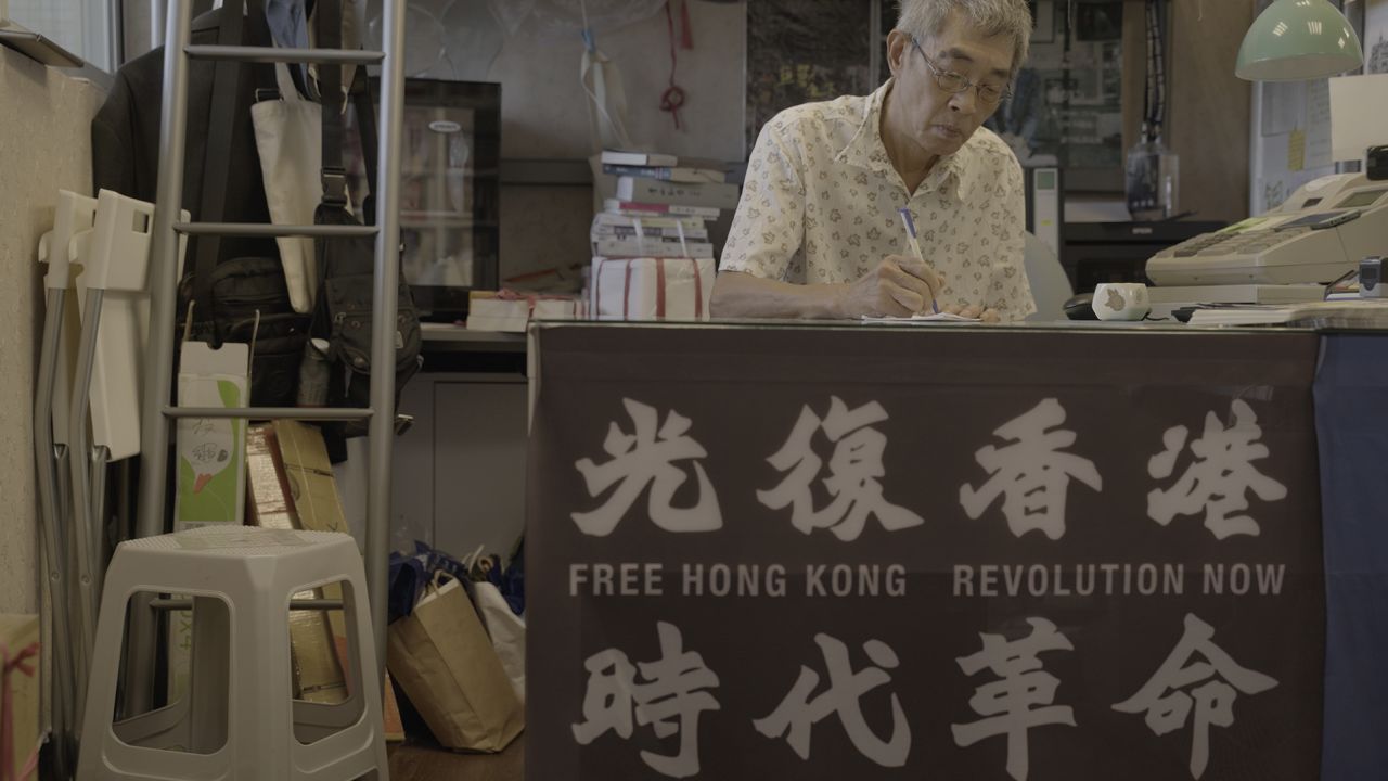 Lam Wing-kee in his Taipei book shop, where a banner displays slogans which have been declared subversive in Hong Kong.