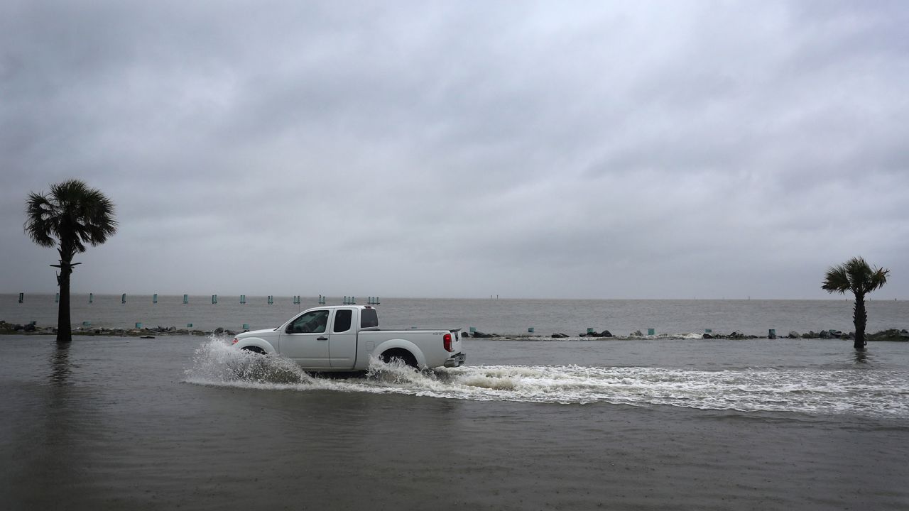 A driver navigates along a flooded road as the outer bands of Hurricane Sally come ashore Tuesday morning in Bayou La Batre, Alabama.