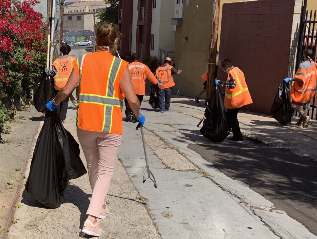 Clad in orange vests, homeless people working with Wheels of Change approach their assigned area to clean up. Wheels of Change pays 20 people each day to pick up litter around San Diego, in an effort to lift them out of homelessness.